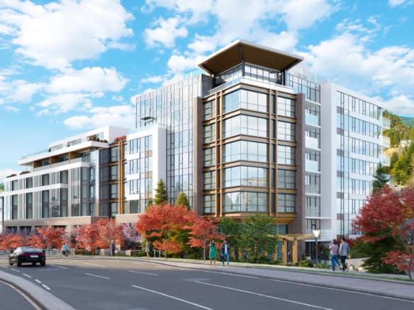 Bright, contemporary condo building in West Vancouver with large glass windows and scenic mountain views.