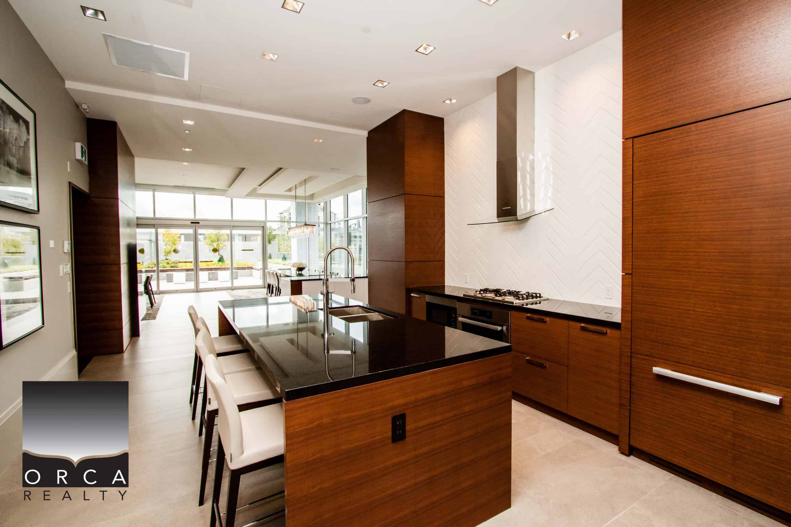 Spacious, contemporary kitchen featuring dark wood cabinets, a large island with seating, and stainless steel appliances, located at 1106-4360 Beresford Street, Vancouver.