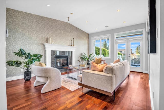Bright and inviting living room with modern furniture, fireplace, and large windows showcasing a scenic view in West Vancouver. Perfect for relaxing and entertaining.
