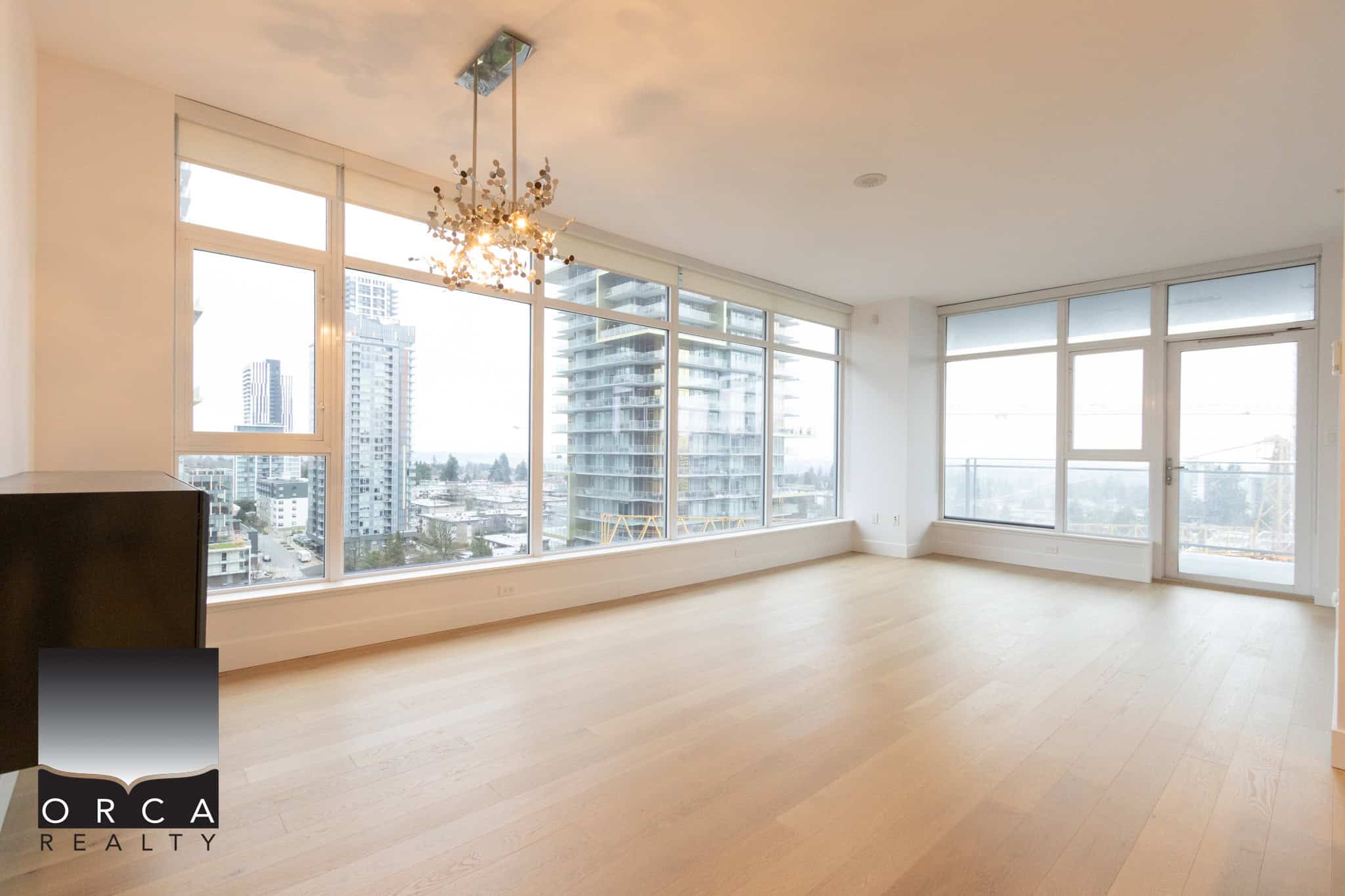 Spacious living room in a high-rise building at 1106-4360 Beresford Street, Vancouver, showcasing natural light and urban scenery.