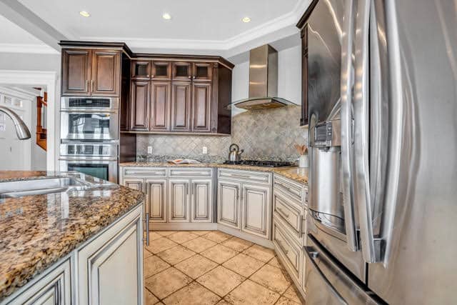 Contemporary kitchen in West Vancouver featuring granite countertops, wooden cabinetry, stainless steel appliances, and a spacious layout. Perfect for luxury living.