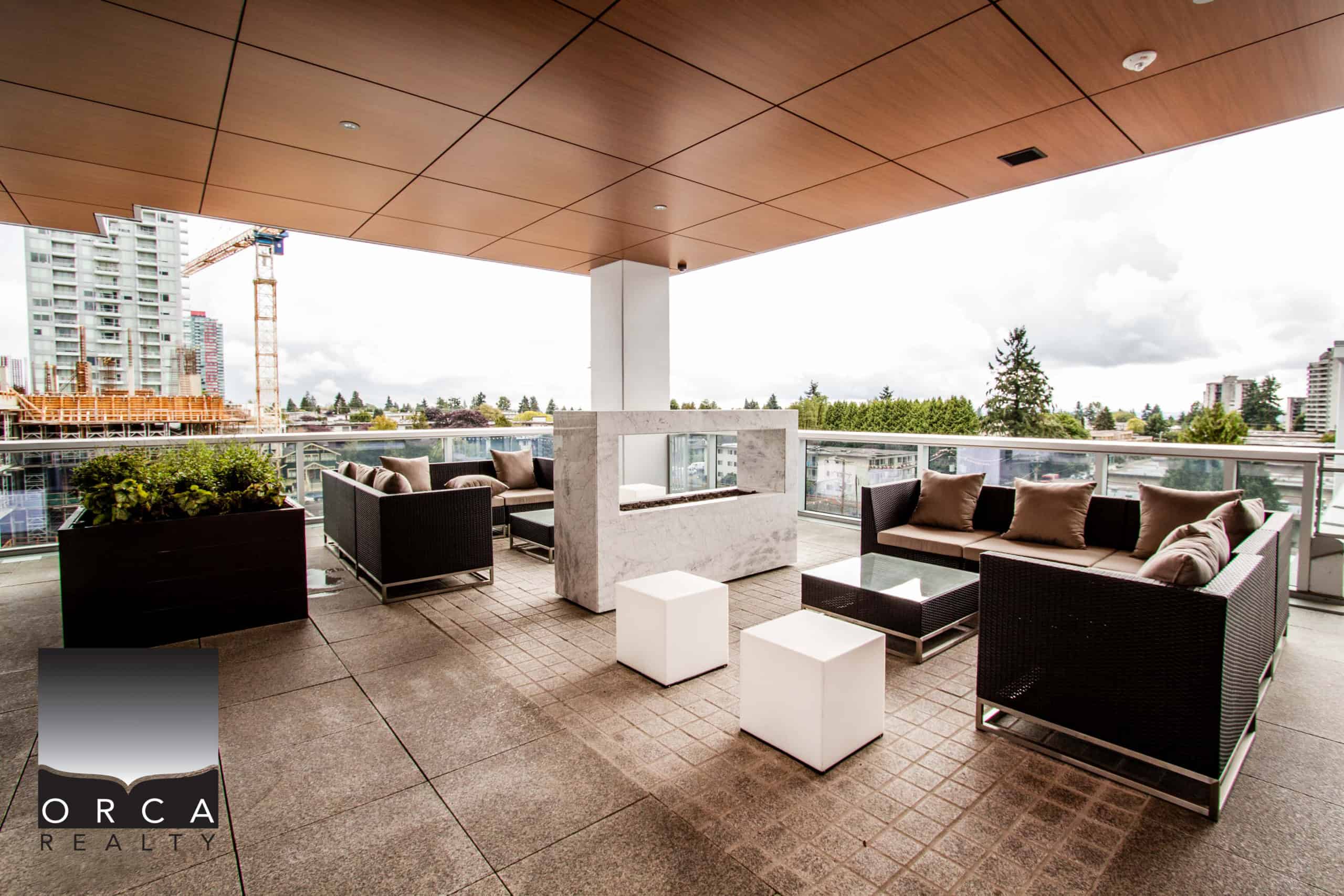 Spacious outdoor balcony at 1106-4360 Beresford Street, Vancouver, featuring comfortable seating and panoramic city views, perfect for relaxing or entertaining guests.