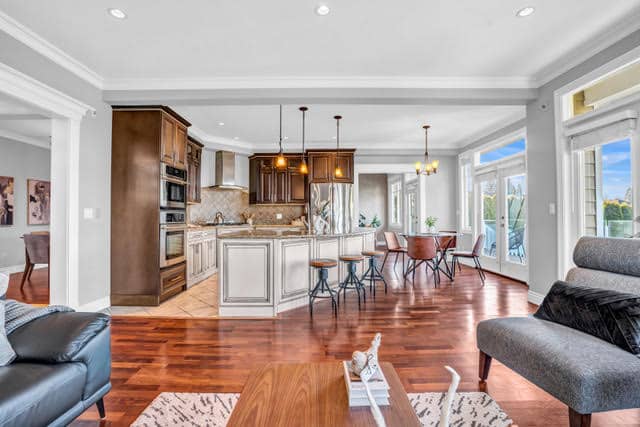 Bright and spacious living area in a West Vancouver home with open-concept kitchen, hardwood floors, and large windows offering scenic views.