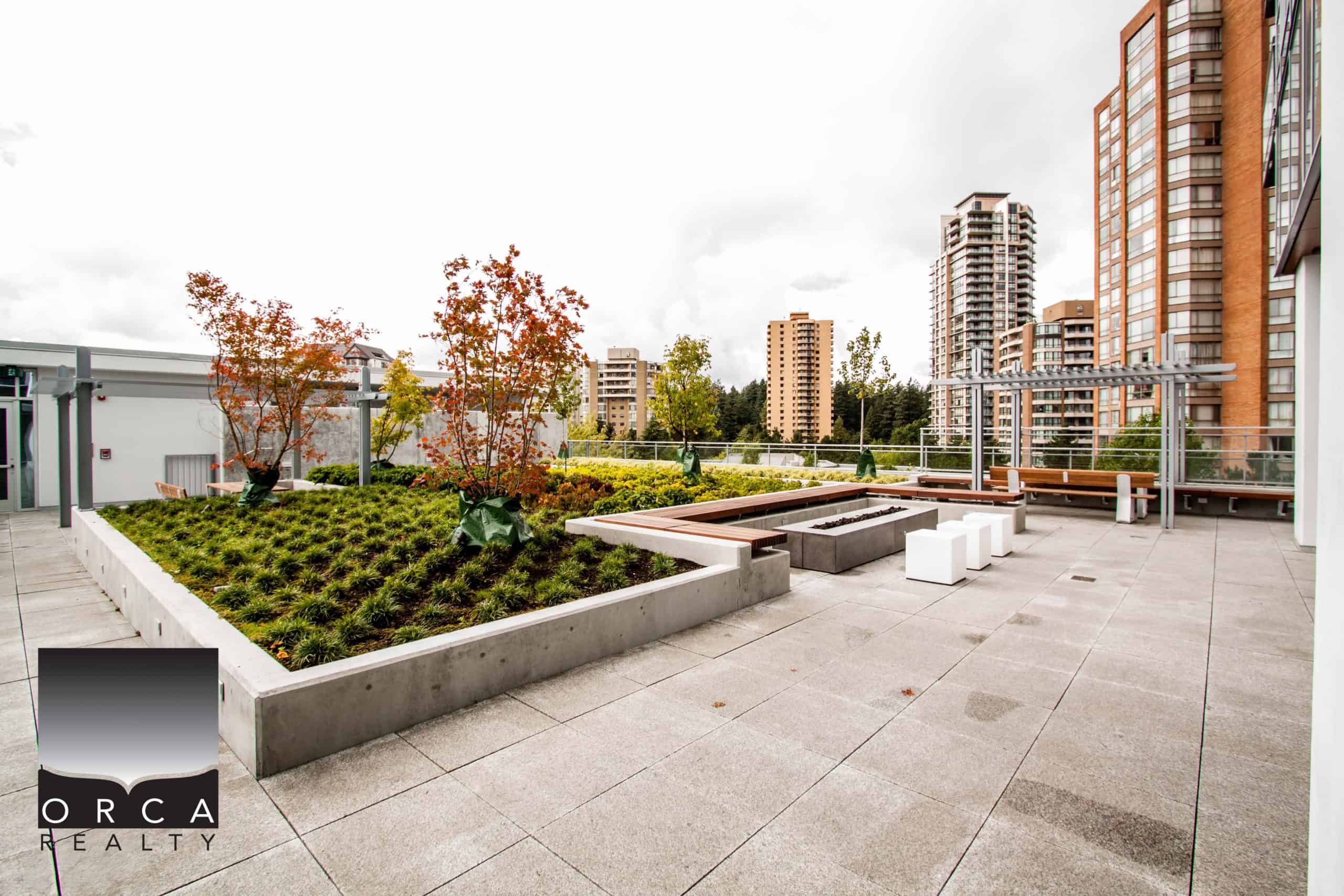 Rooftop terrace at 1106-4360 Beresford Street, Vancouver, showcasing urban outdoor space with greenery, seating, and skyline views, ideal for relaxation and social gatherings.