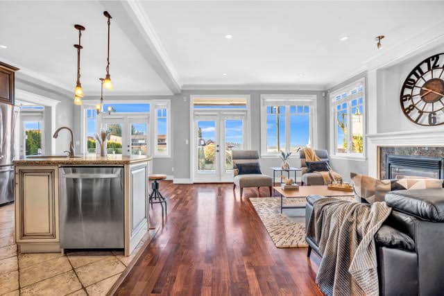 Bright West Vancouver living room with large windows showcasing ocean views, stylish furniture, and open-concept design, perfect for luxury home buyers.