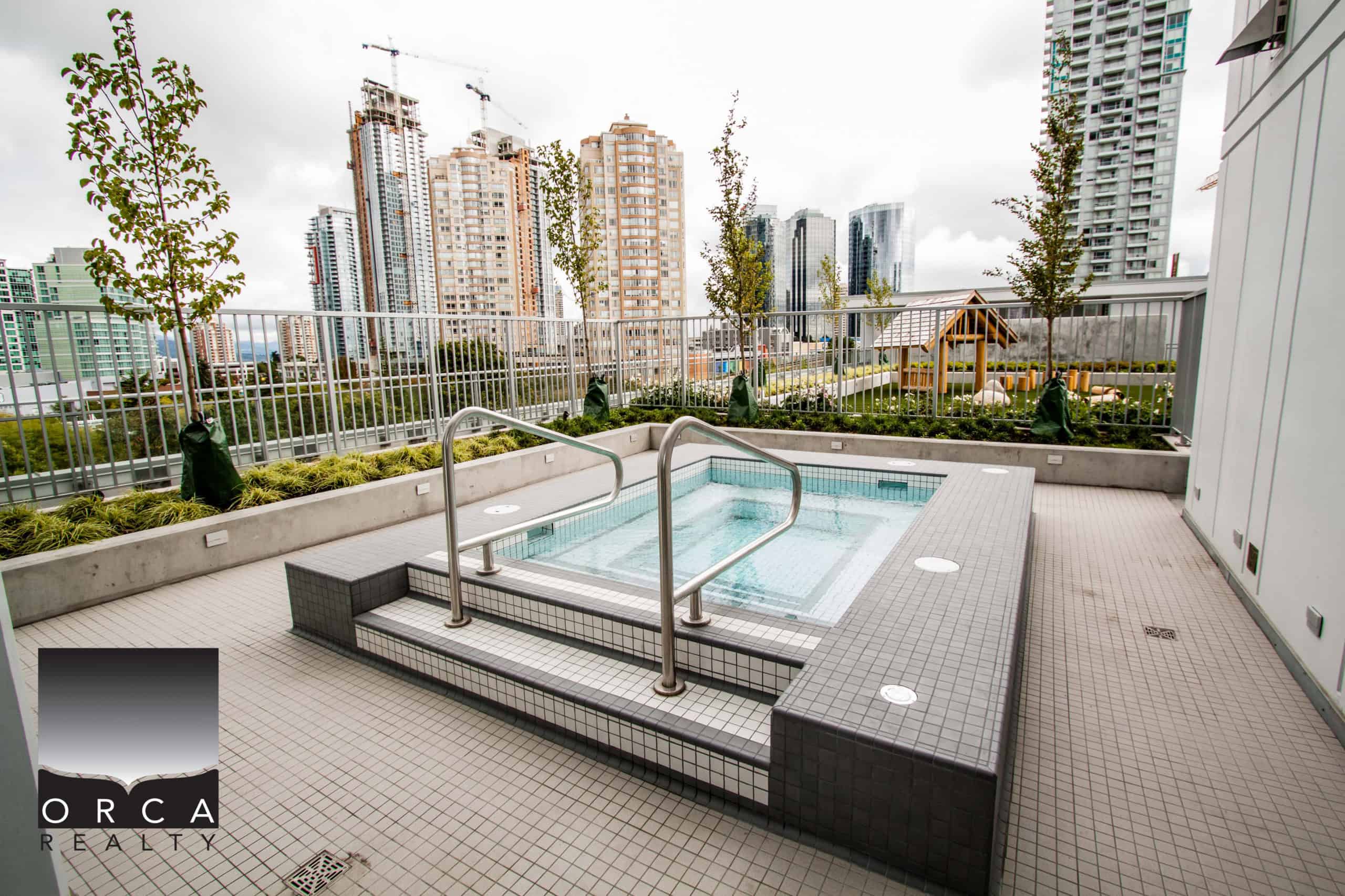 Spacious rooftop hot tub on a condo building terrace in Vancouver, offering stunning city skyline vistas and a relaxing outdoor space for residents.