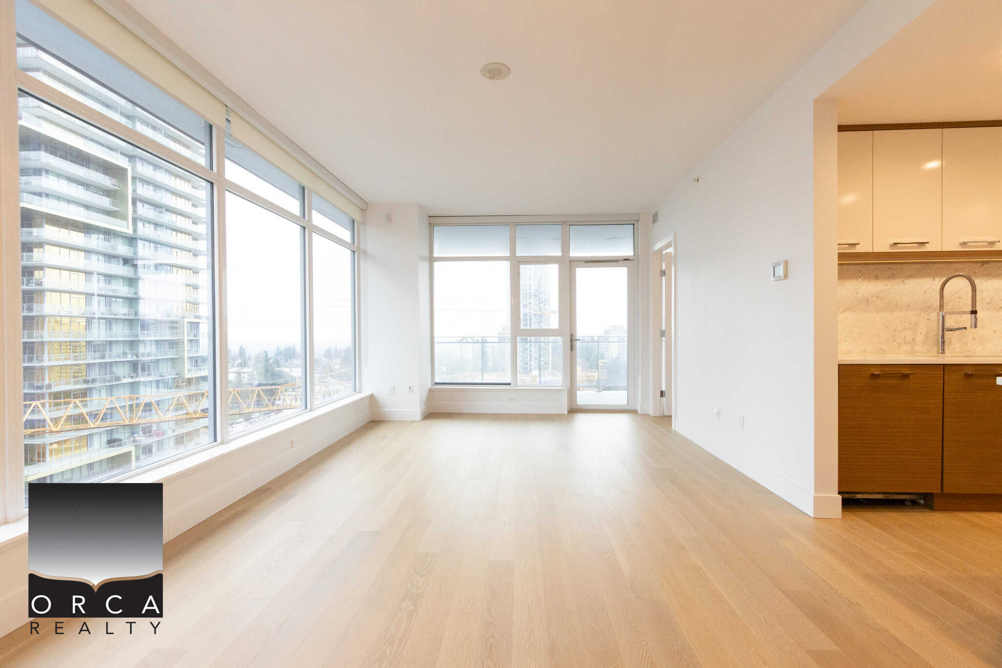 Spacious living area in a Vancouver condo at 1106-4360 Beresford Street, featuring floor-to-ceiling windows, natural light, and an open layout, ideal for urban living and real estate investment.