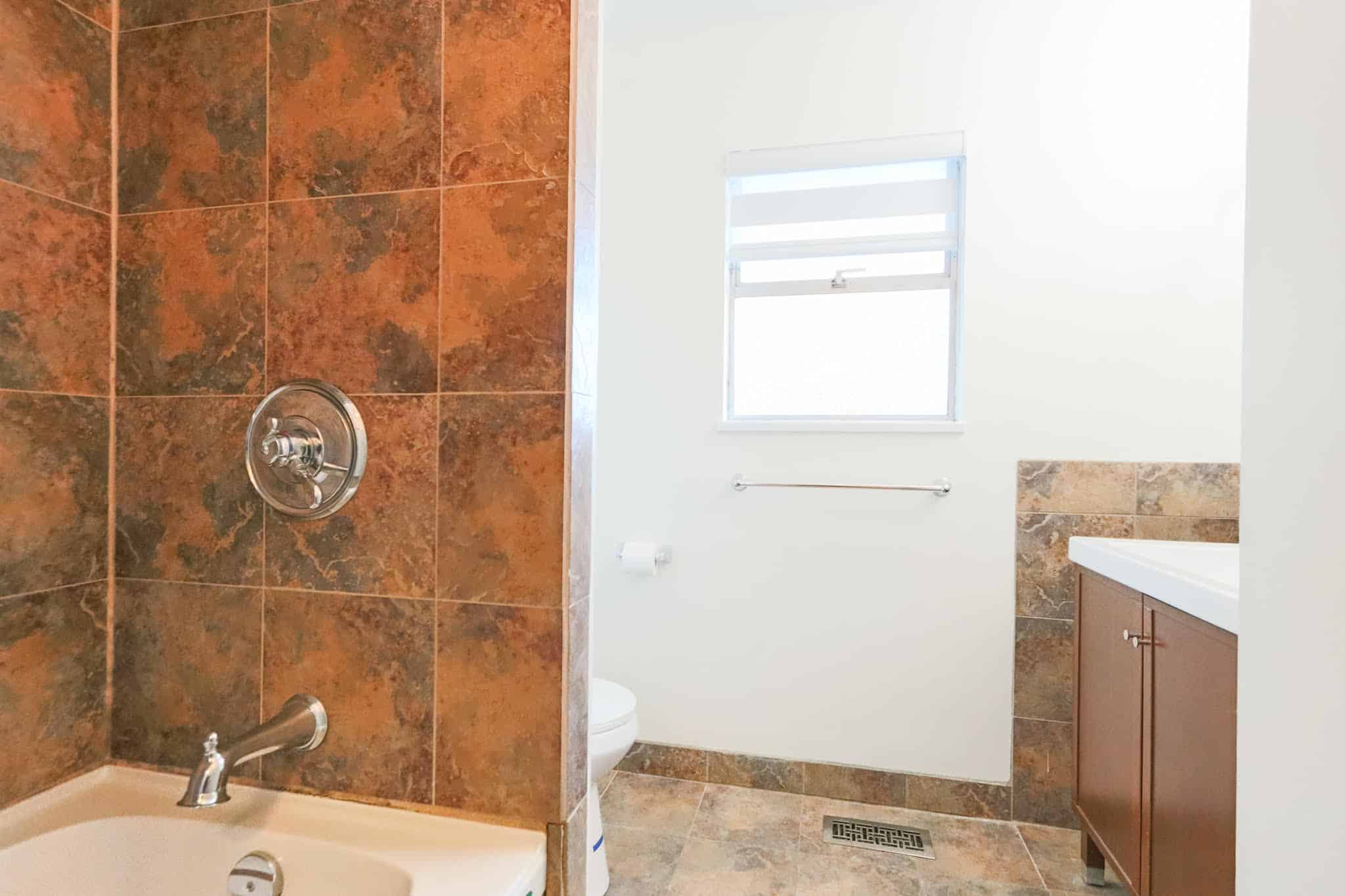 Upstairs bathroom featuring a bathtub, shower, and vanity with storage, located at 10833 85A Avenue, Delta. Perfect for family living with functional design and natural light.
