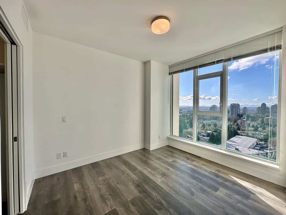 Bright, spacious living room in Edmonds St. Burnaby apartment with large windows and natural light.