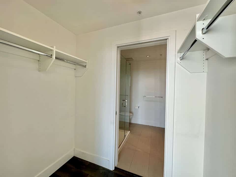 In closet featuring built-in shelves and hanging rods, ideal for organizing clothing and accessories in the Edmonds St. area.
