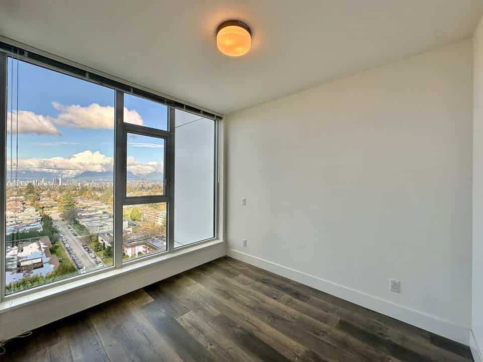 Spacious room featuring a large floor-to-ceiling window with city views in Burnaby, perfect for natural light and urban living.