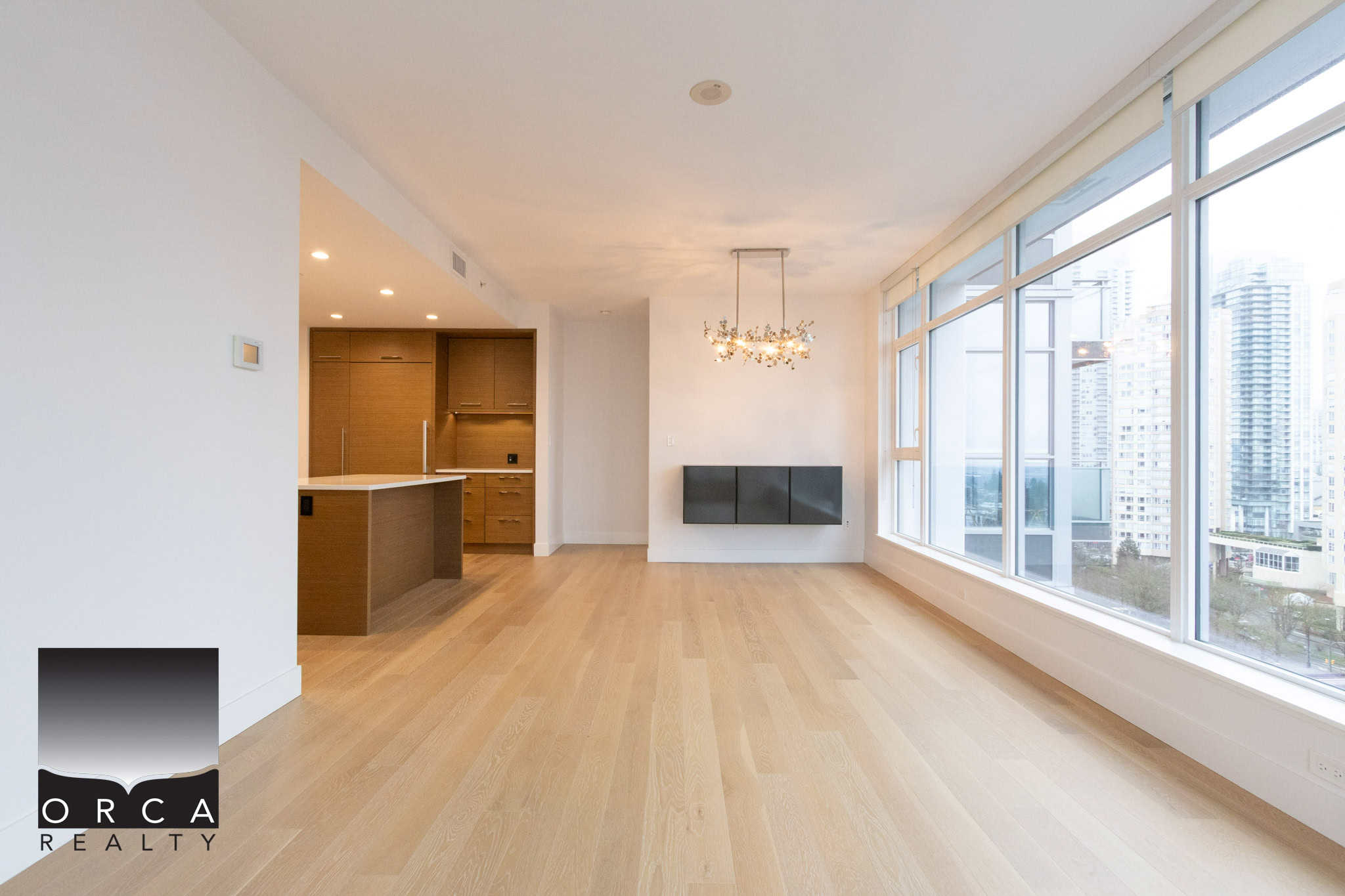 Spacious living area in a Vancouver condo at 1106-4360 Beresford Street, featuring large windows with panoramic city views, hardwood floors, and contemporary design, ideal for urban living.