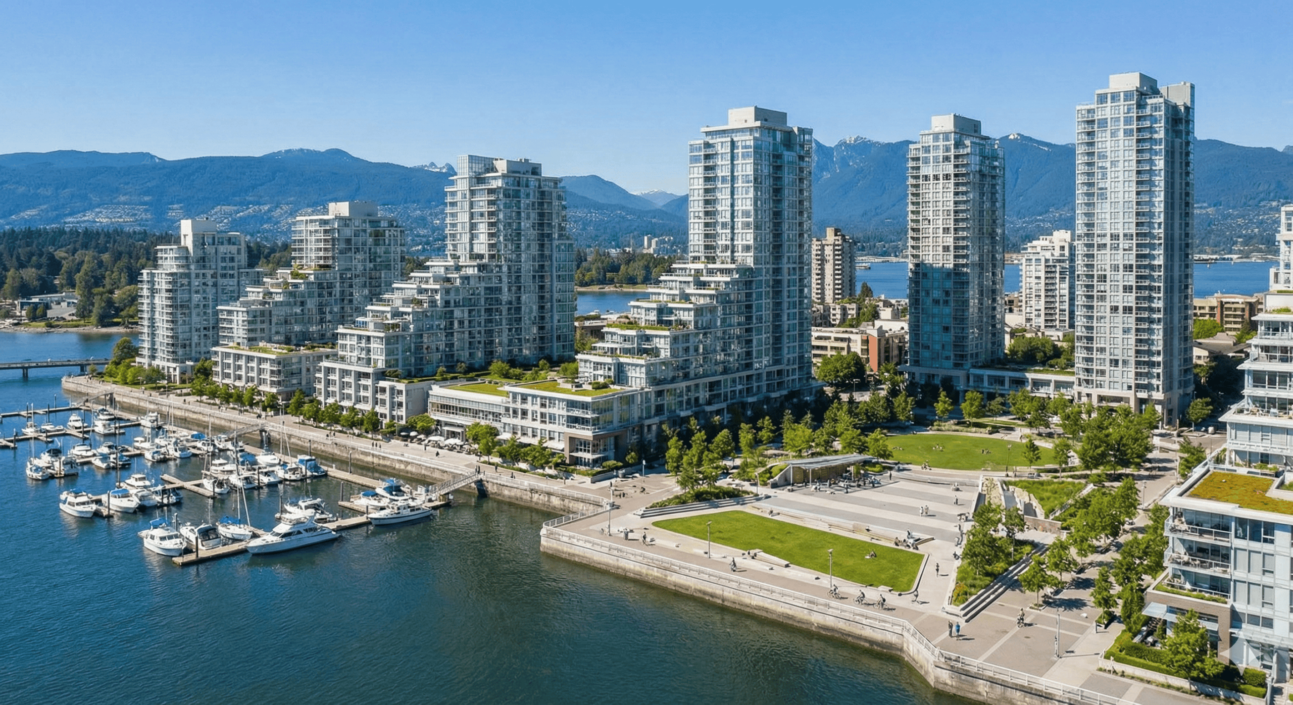 Harbourside waterfront condos with stunning views of the marina and mountains in Vancouver's vibrant harbor area.