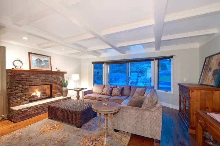 Spacious living room in a West Vancouver home with a cozy fireplace, large windows, and elegant decor, perfect for relaxing and entertaining.