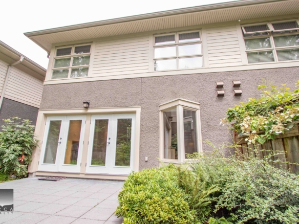 Spacious backyard view of a North Vancouver property with modern patio and lush greenery, perfect for family living and outdoor entertaining.