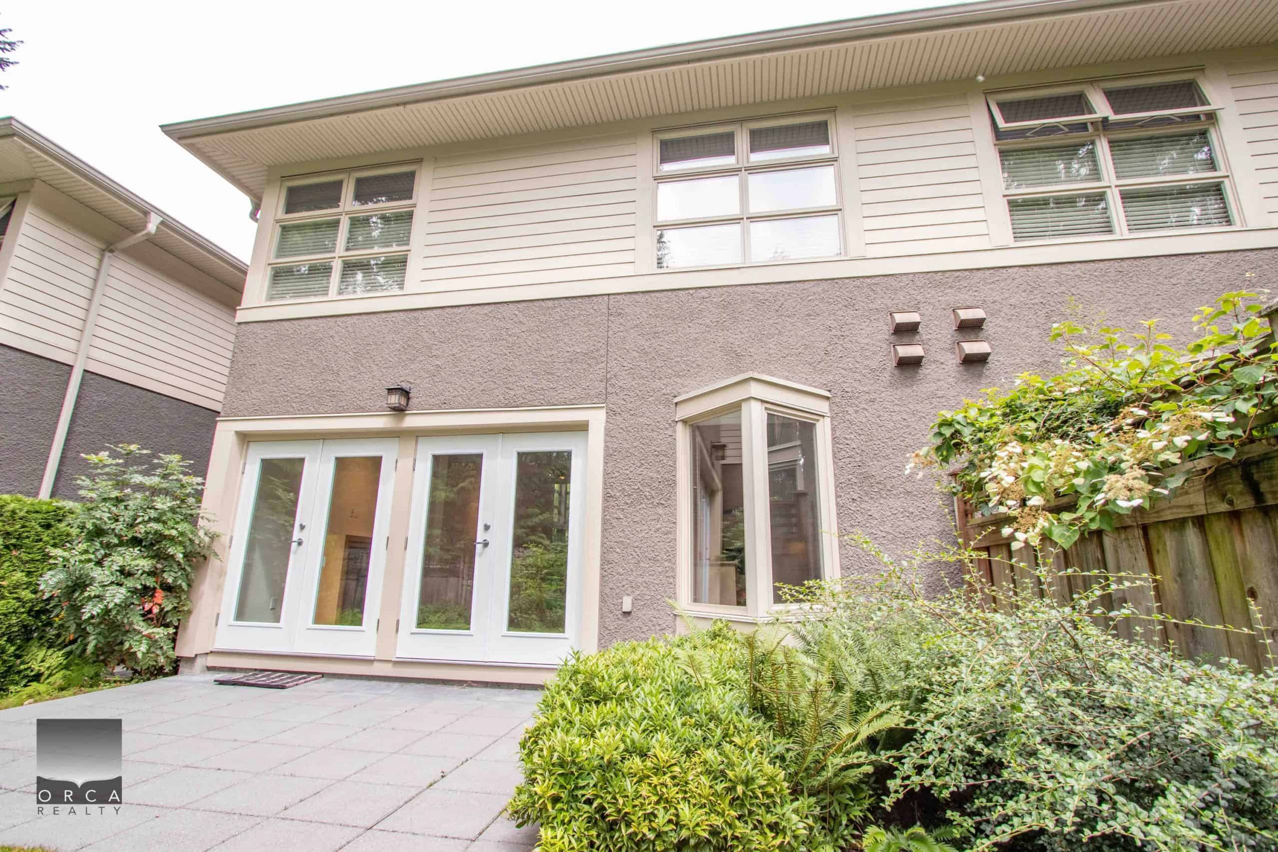 Charming North Vancouver Home Exterior Spacious backyard view of a North Vancouver property with modern patio and lush greenery, perfect for family living and outdoor entertaining.