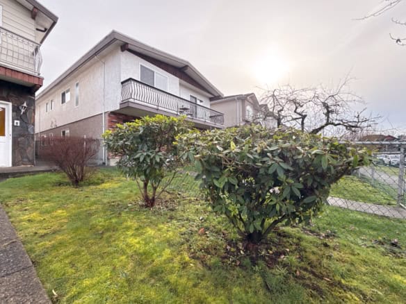 Beautiful Vancouver residential property featuring a well-maintained garden, lush greenery, and a contemporary house with a balcony, located at 6928 Gladstone St.
