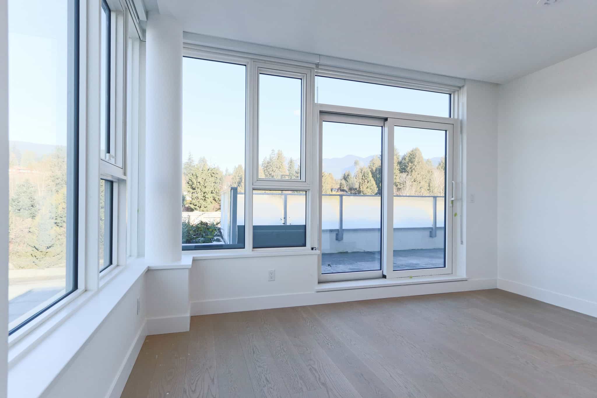 Bright West Vancouver condo with large windows and scenic mountain views.