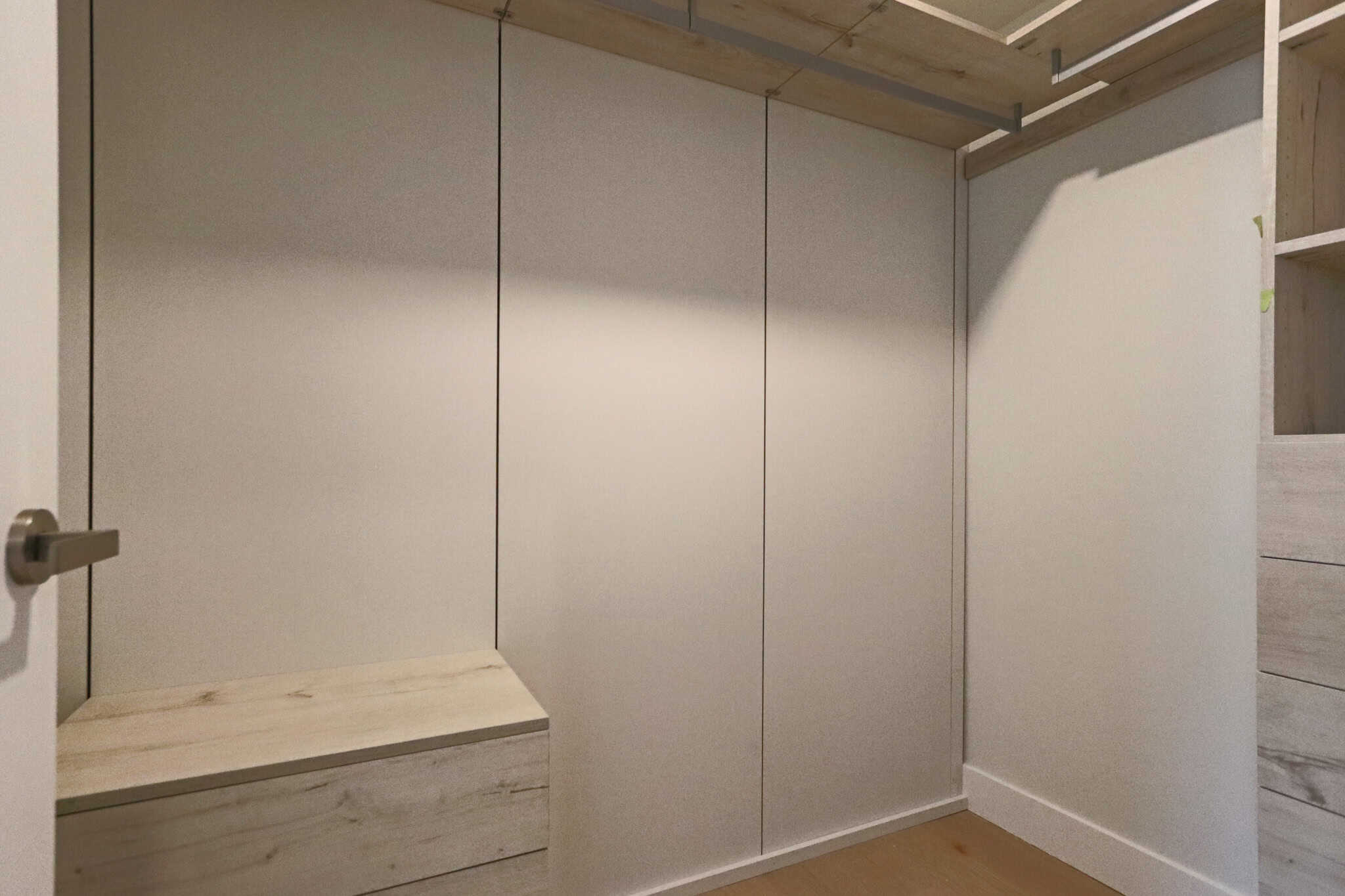 Spacious interior of a walk-in closet featuring minimalist design, custom shelving, and ample storage space, ideal for organizing clothing and accessories in a luxury residence.