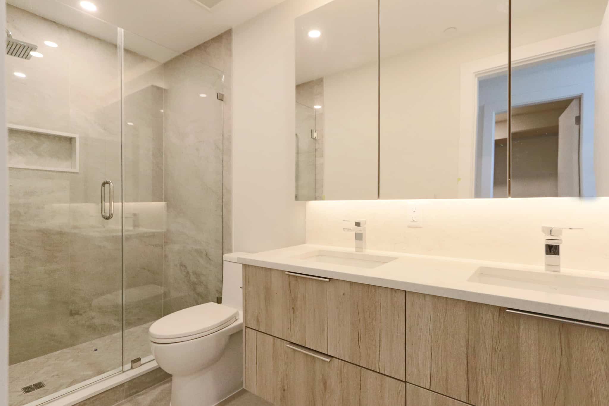 Bright, contemporary bathroom featuring a spacious walk-in shower with glass enclosure and a sleek double vanity with ample storage. Perfect for luxury West Vancouver homes.