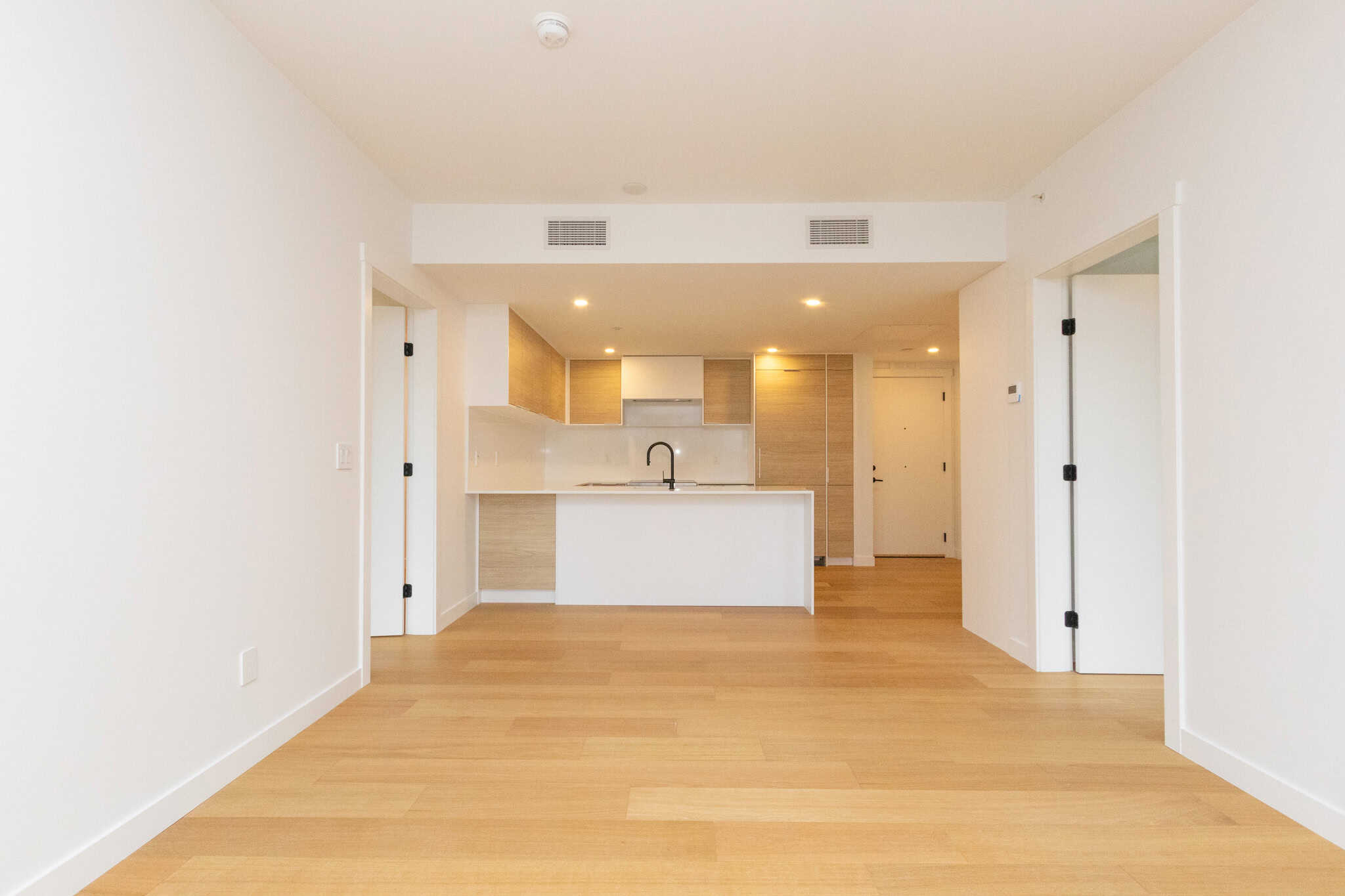 Bright, spacious Vancouver condo interior featuring an open kitchen, minimalist design, and natural light, ideal for modern living in the 405-6485 Manitoba Street area.