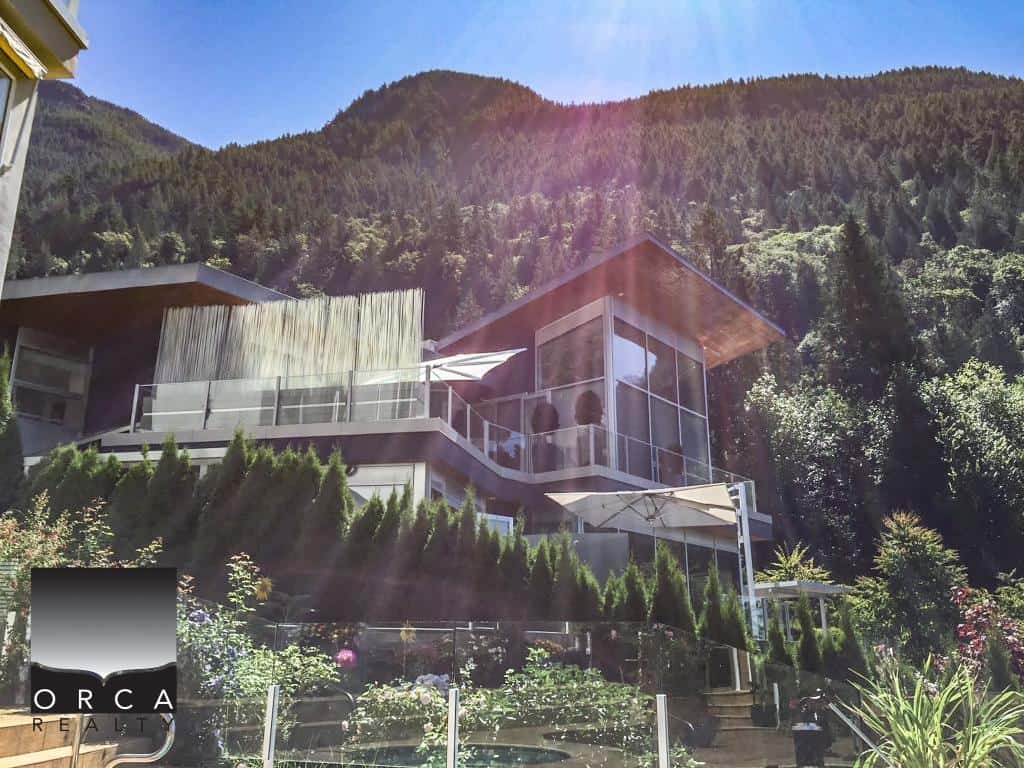 Spacious contemporary house located at Ansell Place, featuring large glass windows and outdoor terraces with stunning mountain scenery in the background.
