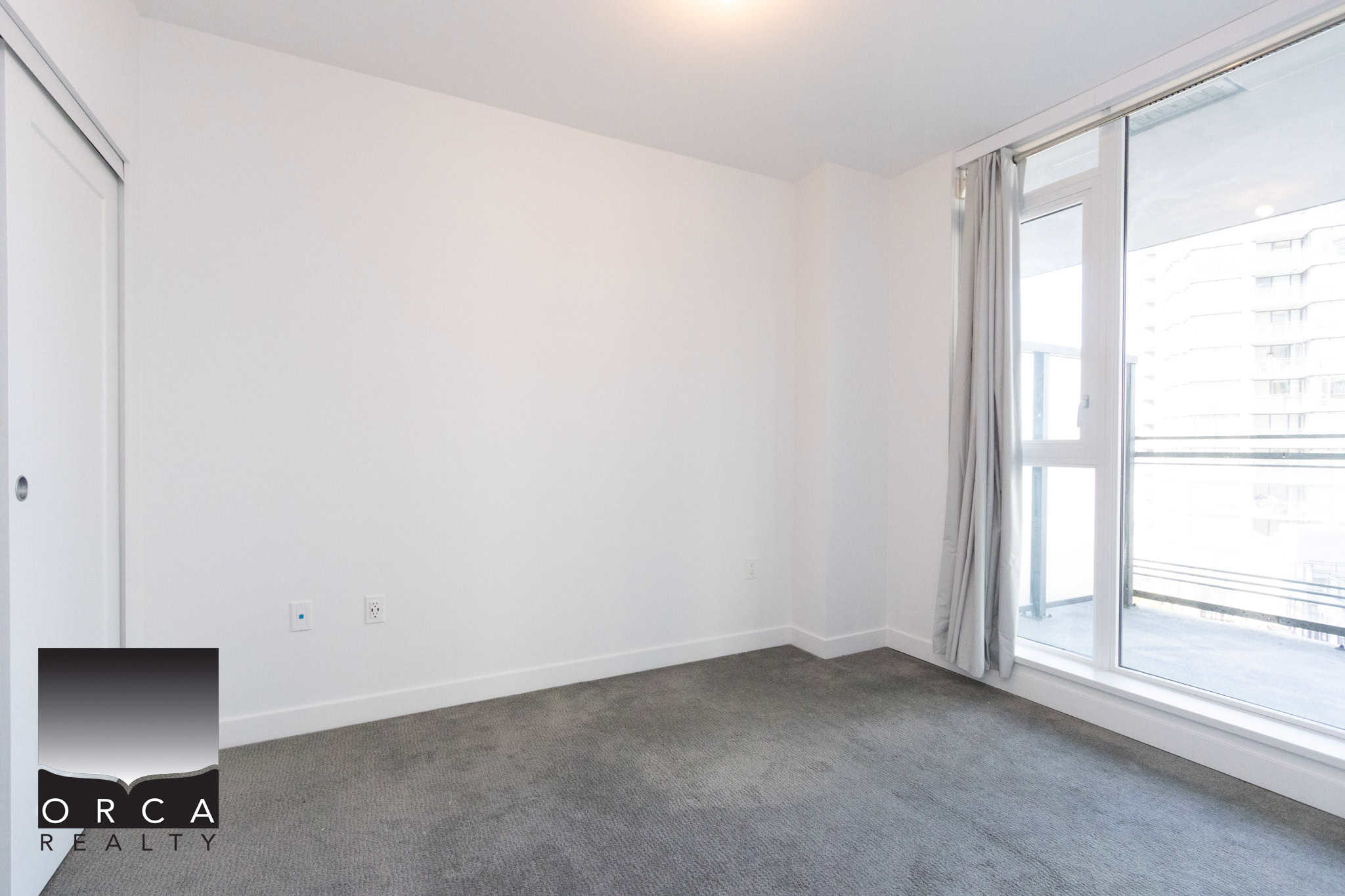 Modern Richmond Condo Interior Bright, empty bedroom with large window and balcony access in Richmond.