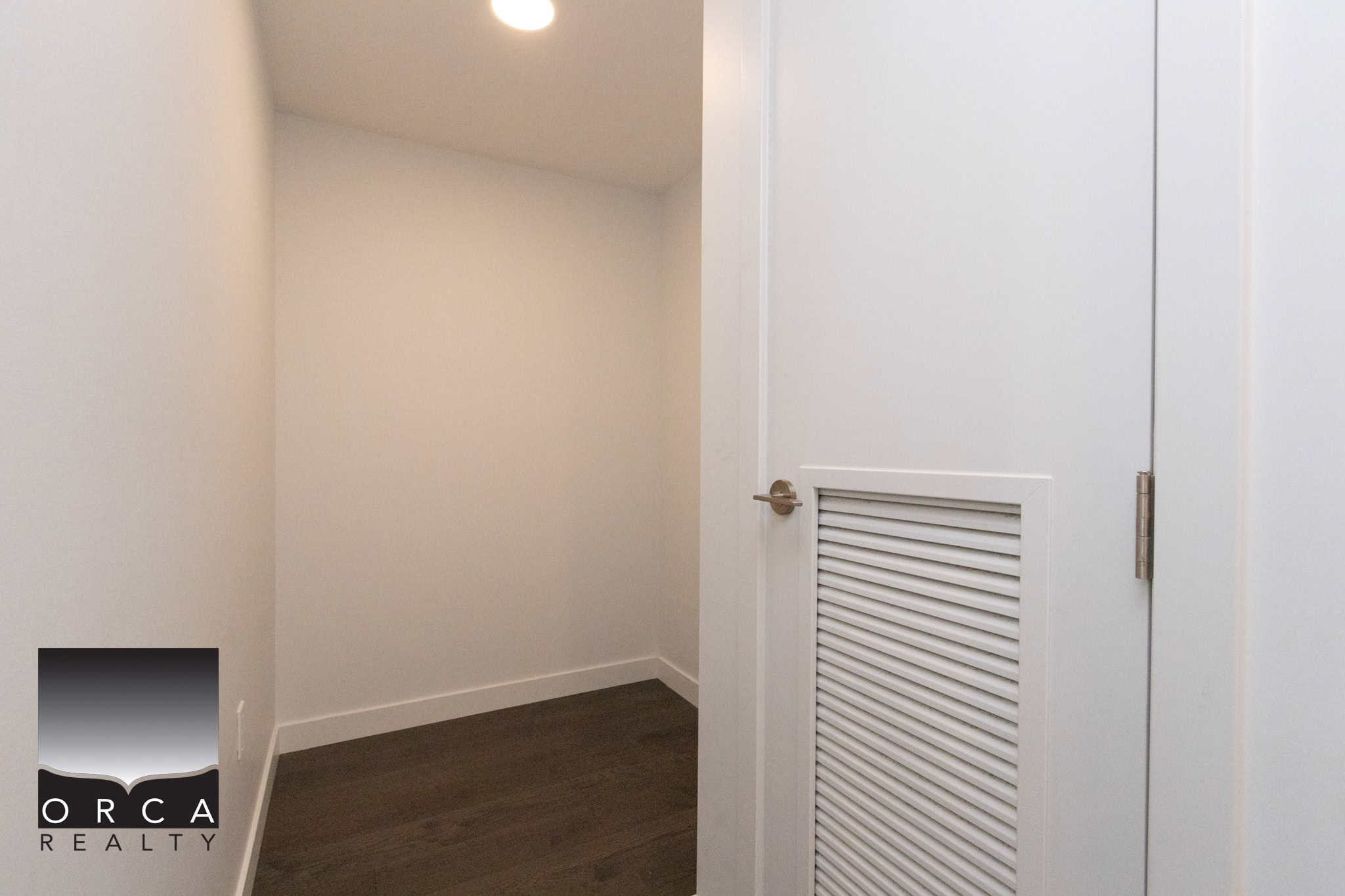 Modern closet space at 702E-3280 Corvee Way, Richmond Spacious interior closet with white walls and dark flooring, ideal for storage or organization in Richmond homes.