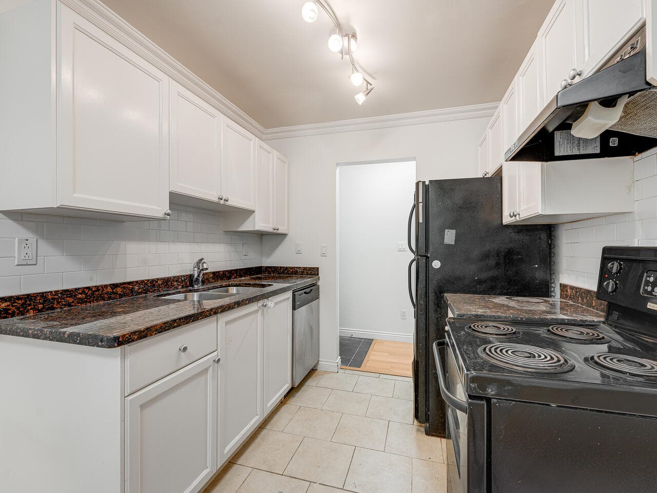 Spacious kitchen featuring white cabinetry, granite countertops, and modern appliances in a Vancouver property listed by Orca Realty Inc.