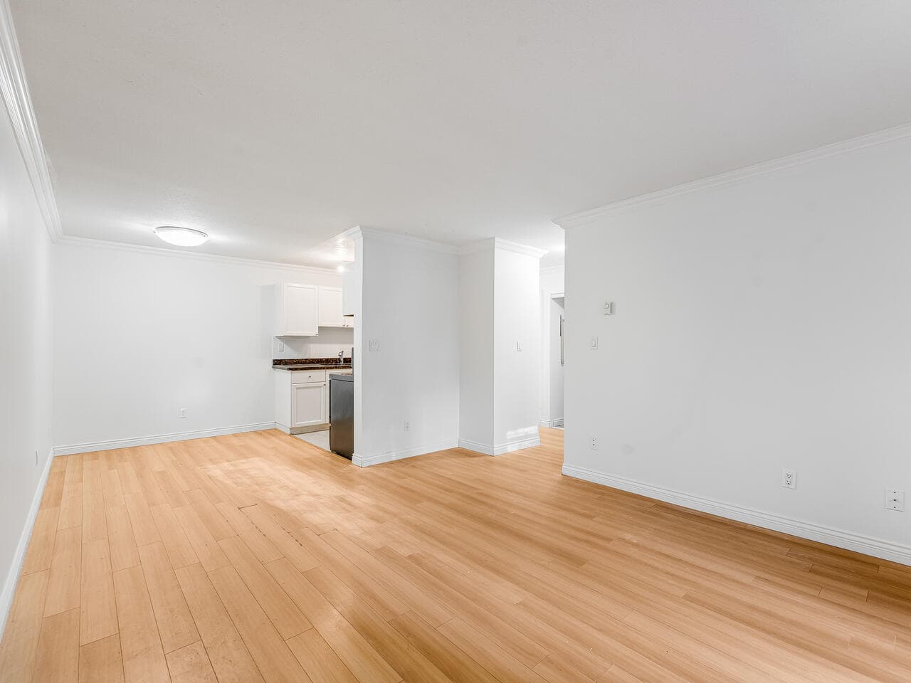 Spacious living area in Vancouver property listed at 112-1550 Barclay St, featuring bright, clean design and hardwood flooring.