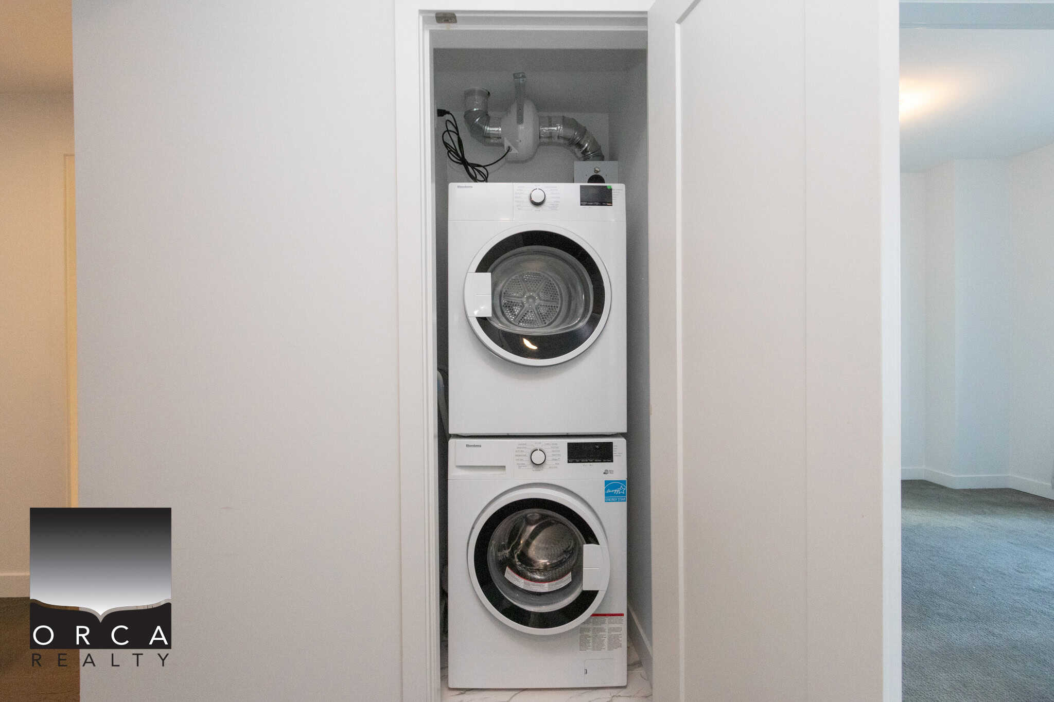 Modern laundry area with stacked washer and dryer units. Efficient laundry space featuring a front-loading washer and dryer in a compact closet.