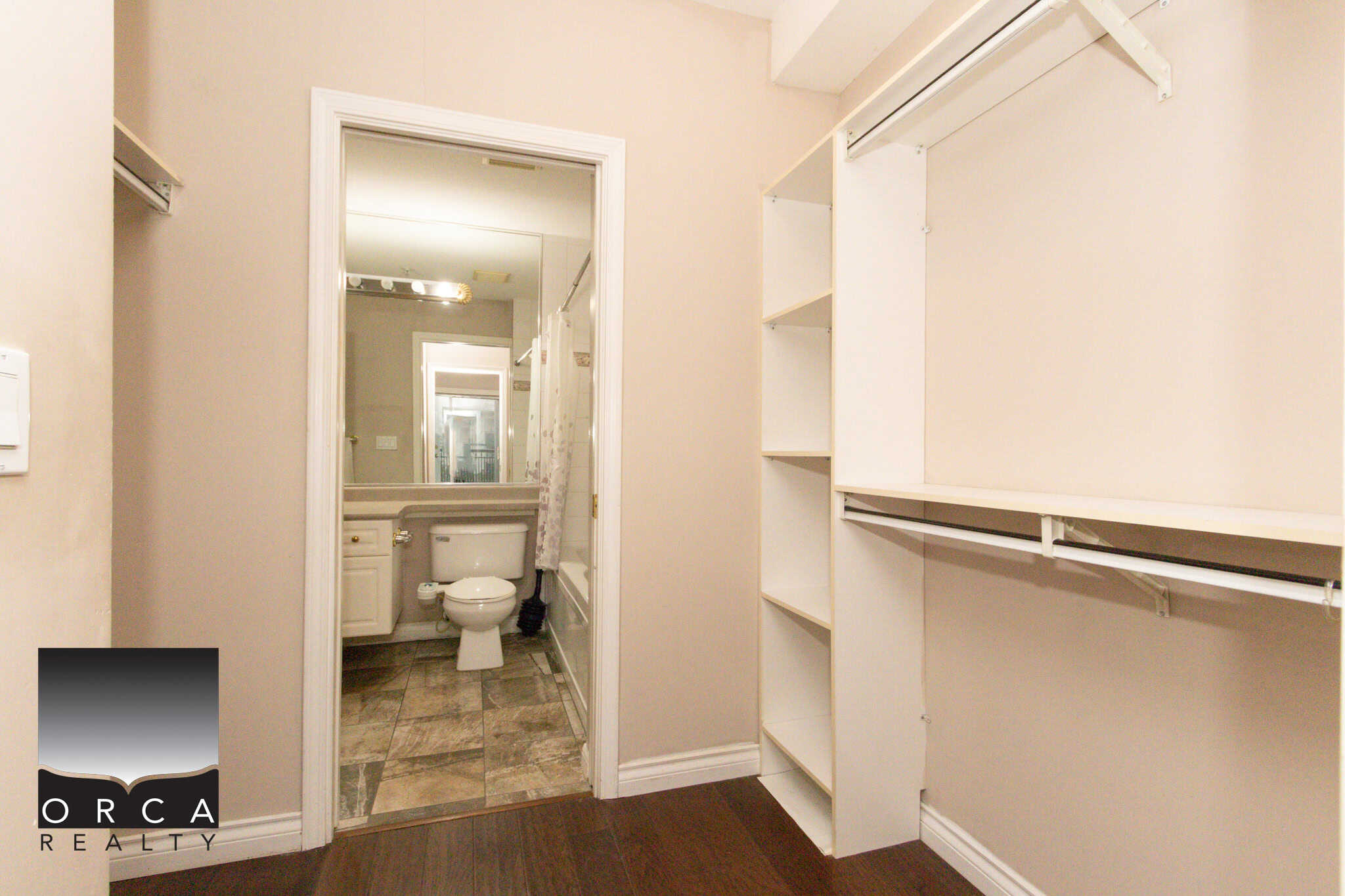 Spacious walk-in closet in a Coquitlam condo, featuring white shelving and hanging space, ideal for organizing clothing and accessories.