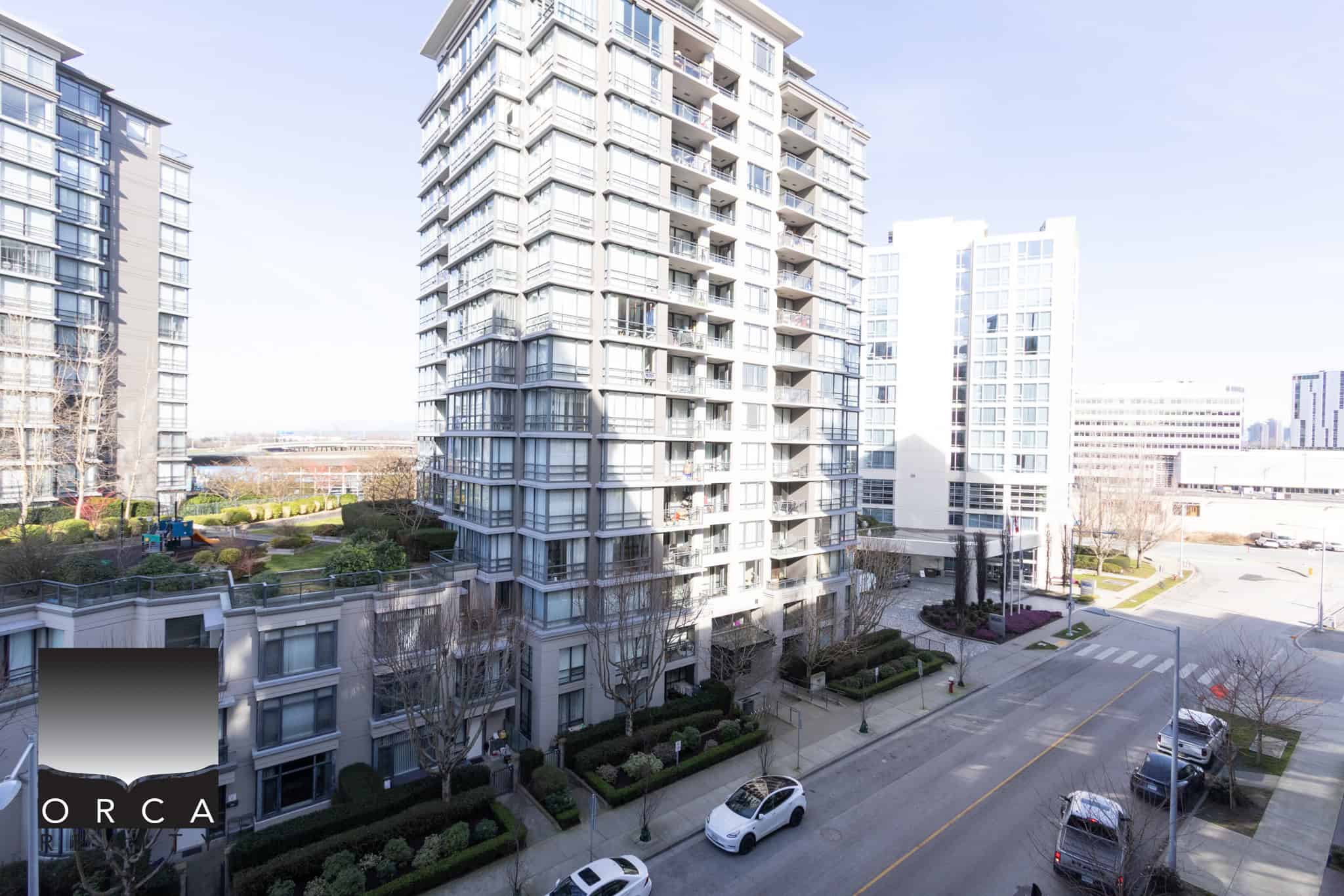 Modern high-rise residential buildings in Richmond, BC. Spacious urban apartment complex at 702E-3280 Corvee Way, featuring contemporary architecture and lush landscaping, ideal for city living.