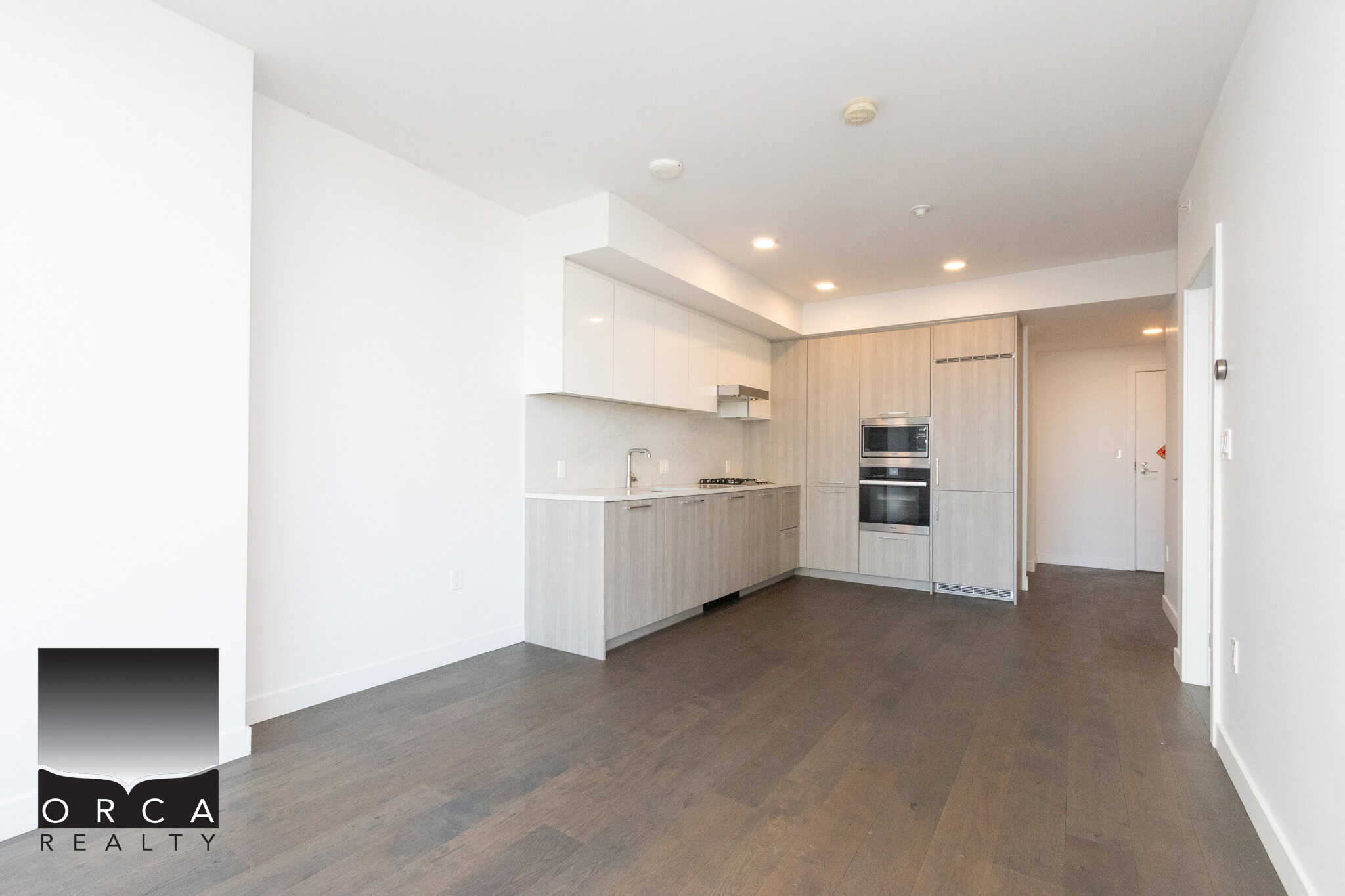 Modern kitchen in Richmond condo with sleek cabinetry and stainless steel appliances. Spacious kitchen in Richmond property featuring contemporary cabinetry, built-in oven, and open layout, ideal for modern living.