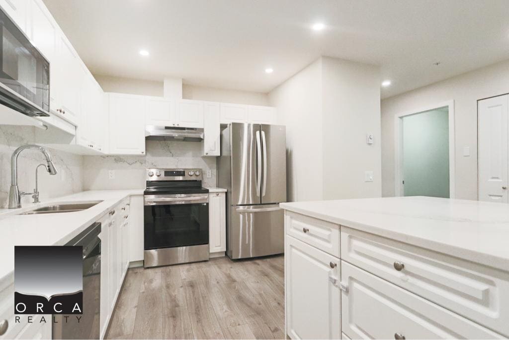 Bright, contemporary kitchen with white cabinets, stainless steel appliances, and ample counter space in Surrey. Ideal for modern lifestyles and home chefs.