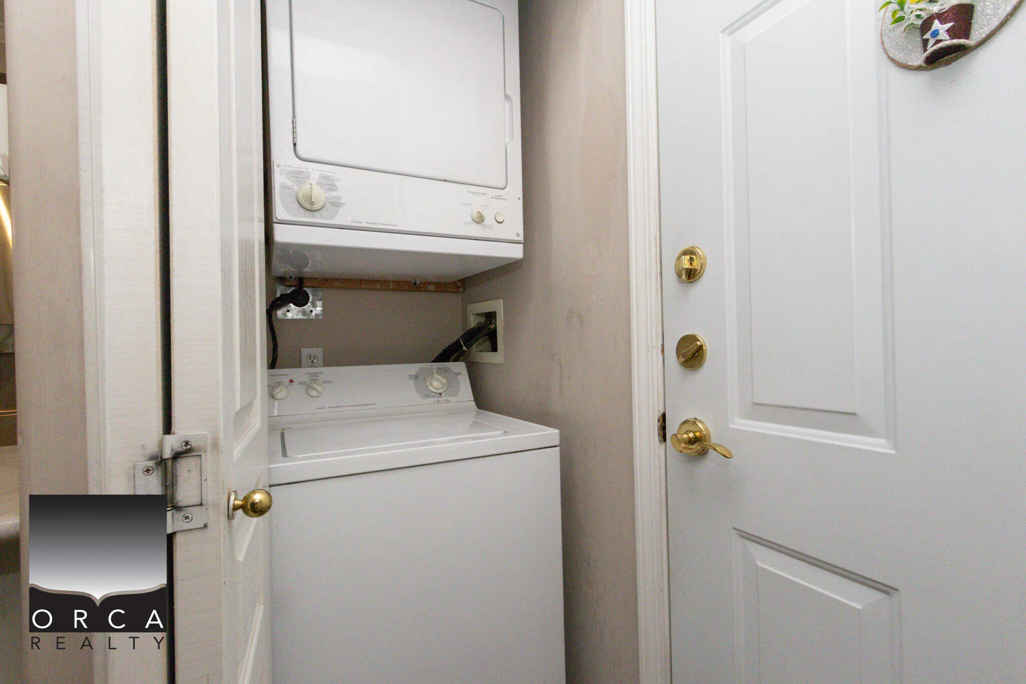 Compact laundry area with stacked washer and dryer units in a cozy home.