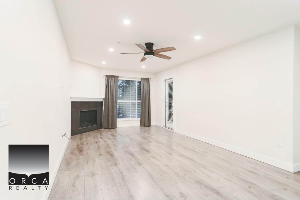 Spacious and bright living room in Surrey, featuring a cozy fireplace, large windows with natural light, and neutral decor, perfect for family living and entertaining.