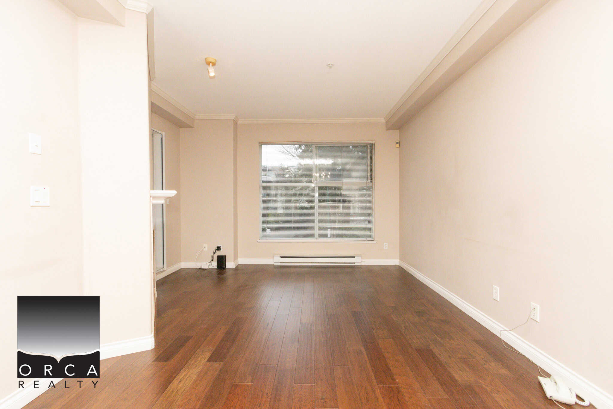 Coquitlam real estate, spacious living room, hardwood flooring, large window, natural light, residential property, Orca Realty Inc.