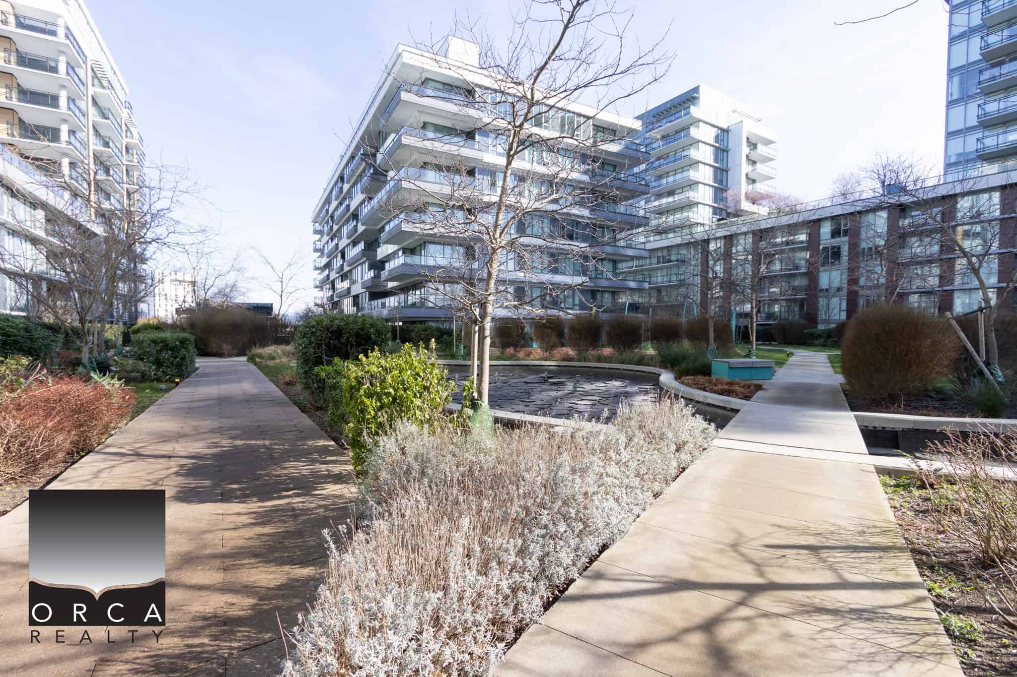 Modern Richmond condo complex with landscaped pathways Scenic view of landscaped pathways and modern residential buildings in Richmond, BC, showcasing outdoor spaces and urban living at 702E-3280 Corvee Way.