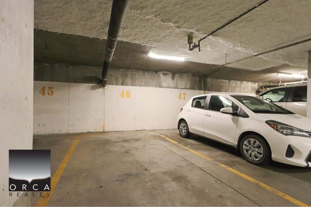 Underground parking space at 410-15895 84th Ave, Surrey, with a white car parked in a designated spot.