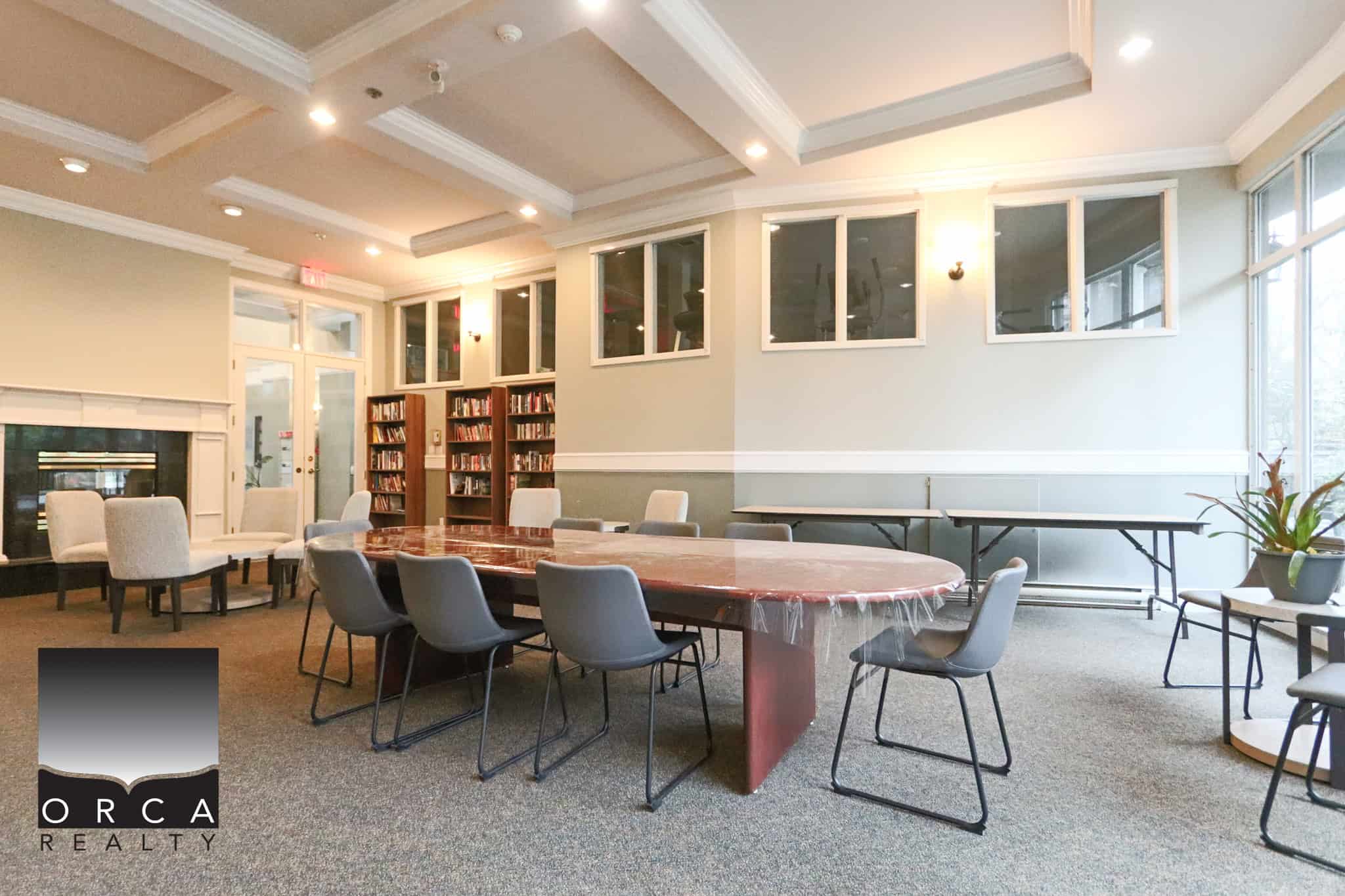 Bright and spacious meeting room in Coquitlam with large windows, comfortable chairs, and a central table, ideal for business meetings and community events.