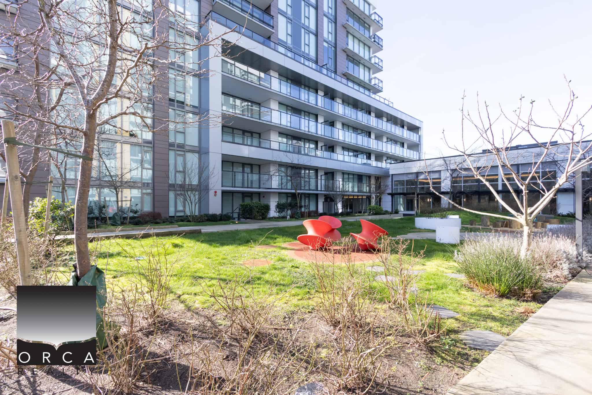 Modern Richmond Condo Exterior Bright, spacious outdoor area at 702E-3280 Corvee Way, Richmond, featuring landscaped gardens and seating areas.