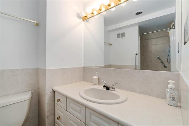 Bright bathroom featuring a white vanity, mirror, and modern fixtures in a West Vancouver residence.