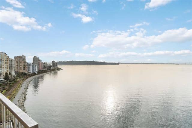 Stunning waterfront scene of West Vancouver with calm waters, city skyline, and clear blue sky, ideal for real estate listings and property showcases.