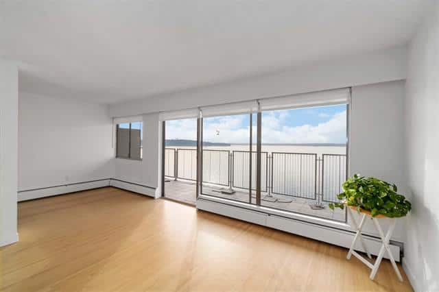 Bright living room with large windows and balcony view in West Vancouver.