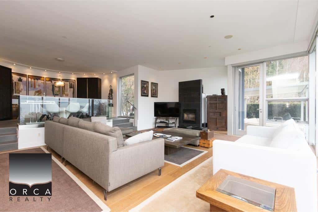 Spacious living room with comfortable sofas, large windows, and stylish decor at Ansell Place, a prime property listed by Orca Realty Inc.