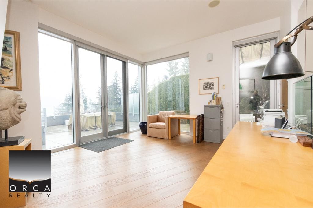 Bright and spacious living room featuring large glass doors opening to a balcony with scenic outdoor views. Perfect for relaxing or entertaining in a contemporary home.