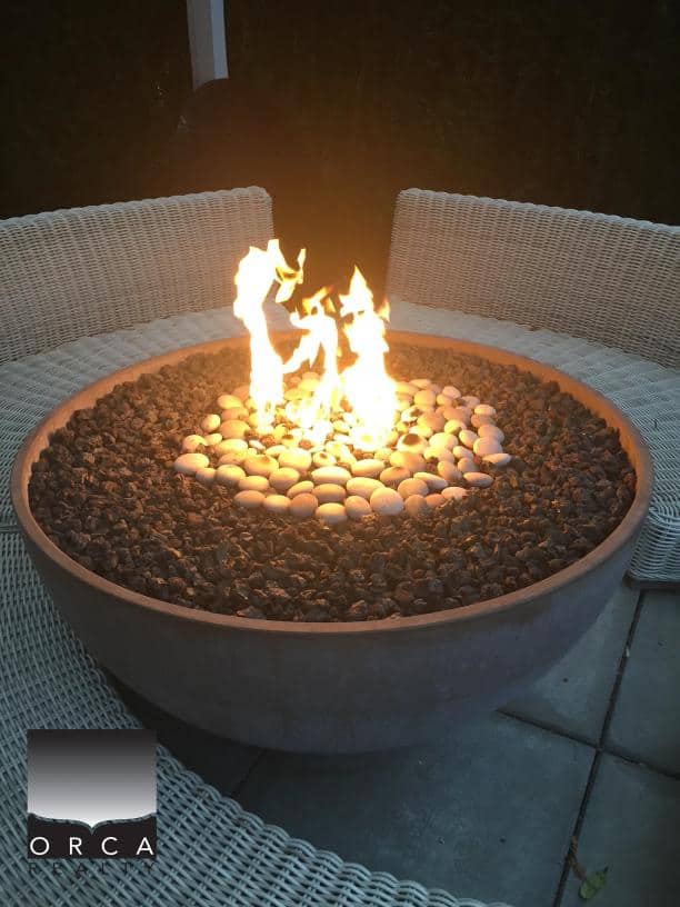 Fire pit with flames surrounded by stones, creating a cozy outdoor ambiance.