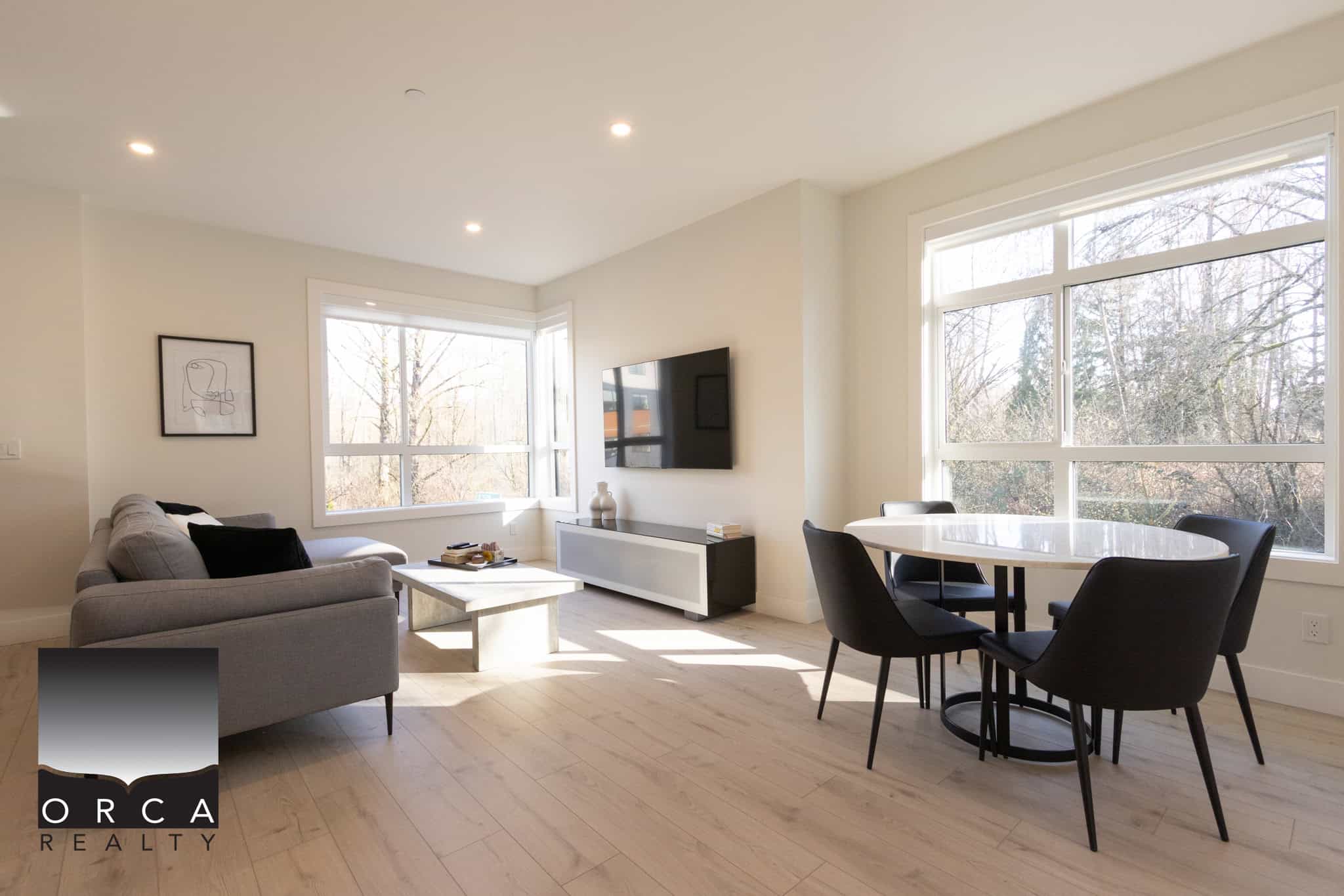 Bright and spacious living room in Langley featuring large windows that bring in natural light, hardwood floors, and contemporary furniture, perfect for relaxing or entertaining.