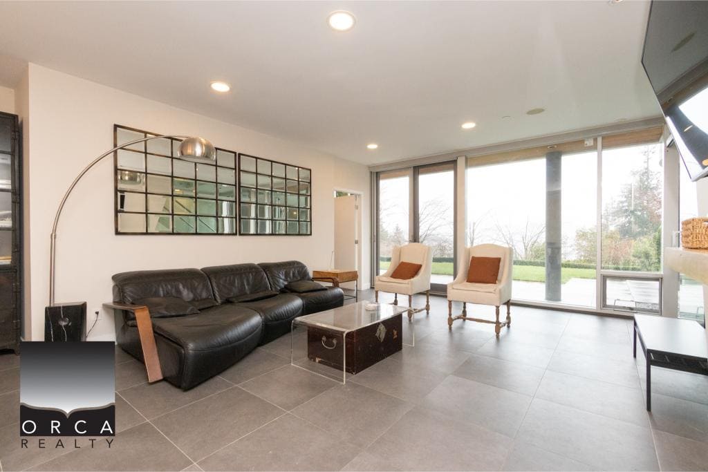 Spacious living room at Ansell Place featuring large windows, contemporary furniture, and stylish decor, perfect for relaxing or entertaining guests.